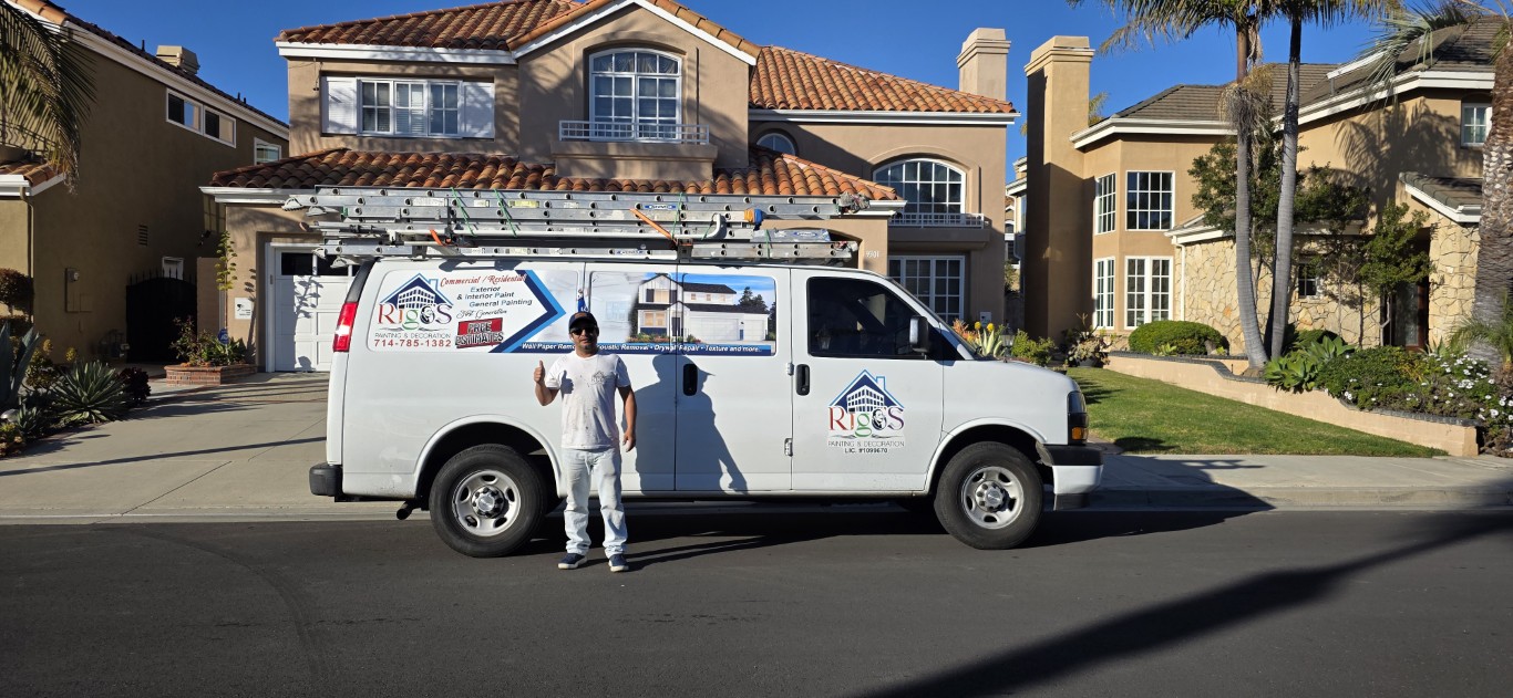 Rigos Painting team member with branded service van in front of a Southern California home